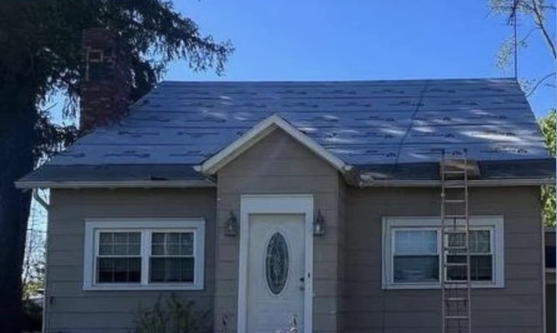 Erie, PA home with a worn, patched shingle roof before EJ replaced it